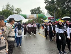 Ditengah Hujan Deras, Personel Polres Bintan Tetap Lakukan pengamanan Lomba Gerak Jalan